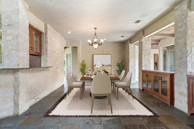 24736 Travis Lakeside Cv, Spicewood, TX 78669 - dining space with stone tile flooring, a chandelier, and healthy amount of natural light