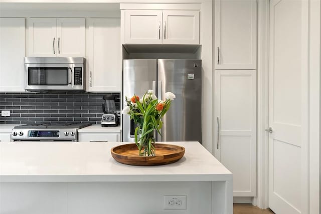 1503 Richcreek Rd Unit A, Austin, TX 78757 - kitchen with stainless steel appliances, light countertops, decorative backsplash, and white cabinetry