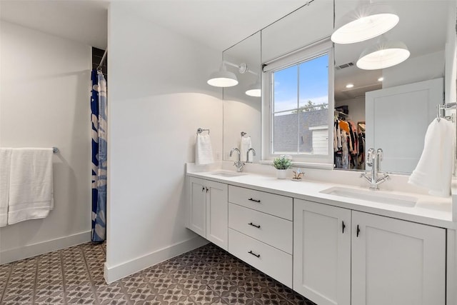 1503 Richcreek Rd Unit A, Austin, TX 78757 - bathroom featuring tile patterned floors, double vanity, and a walk in closet