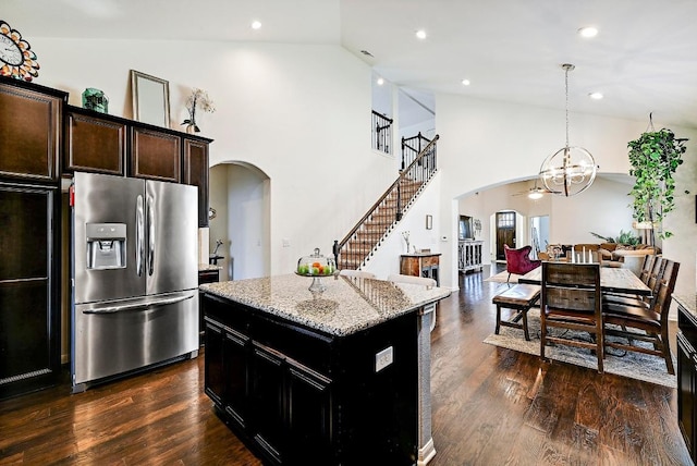 2605 Etta May Ln, Leander, TX 78641 - kitchen with stainless steel refrigerator with ice dispenser, arched walkways, a center island, light stone counters, and high vaulted ceiling