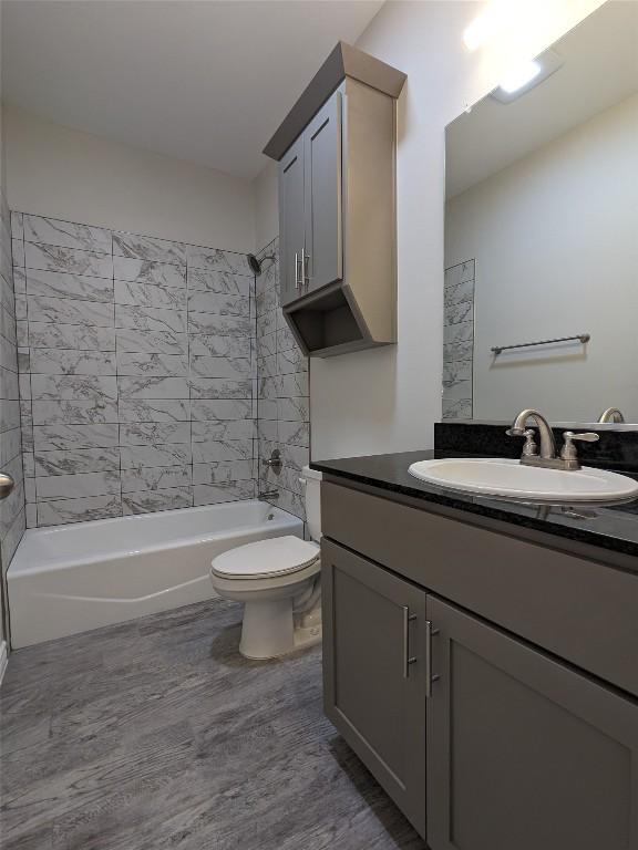 407 Gamel St, Lampasas, TX 76550 - bathroom featuring wood finished floors, vanity, and shower / washtub combination