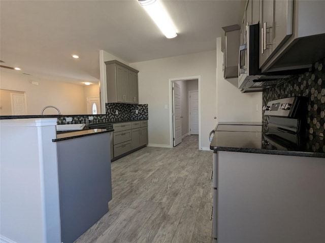 407 Gamel St, Lampasas, TX 76550 - kitchen with dark countertops, gray cabinetry, decorative backsplash, light wood-style flooring, and recessed lighting