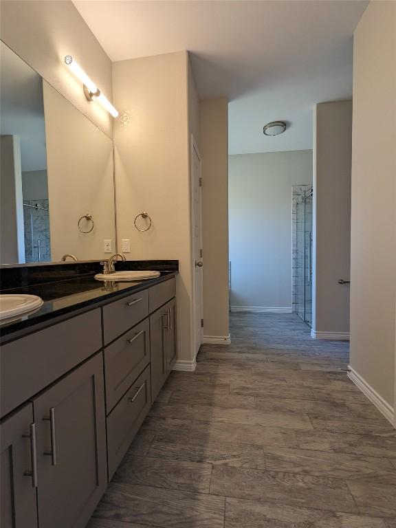 407 Gamel St, Lampasas, TX 76550 - full bath with double vanity, a shower, and wood finished floors
