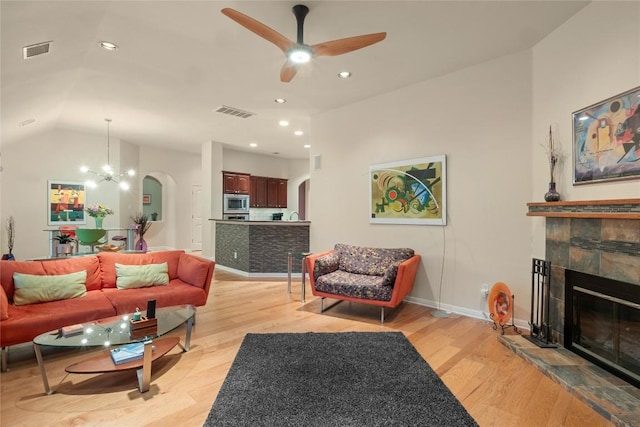 2009 Manada Trl, Cedar Park, TX 78641 - living room featuring arched walkways, light wood-style floors, ceiling fan, a fireplace, and recessed lighting