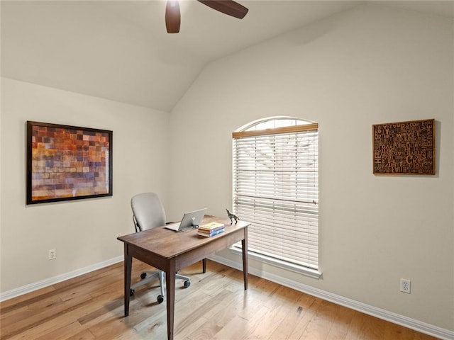 office featuring light wood finished floors, baseboards, vaulted ceiling, and ceiling fan