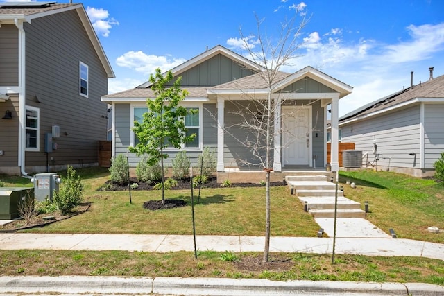 197 Buenos Aires, Kyle, TX 78640 - view of front of home with board and batten siding, a front yard, and central AC unit