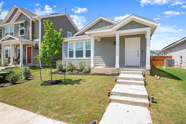 197 Buenos Aires, Kyle, TX 78640 - view of front of home featuring a porch, board and batten siding, central AC, and a front yard
