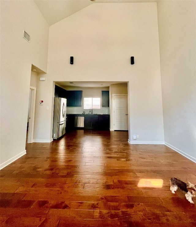 2101 Rivers Edge Way Unit 17, Austin, TX 78741 - unfurnished living room with dark wood-style floors, a sink, high vaulted ceiling, and baseboards
