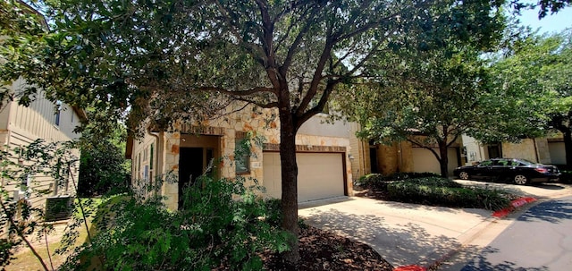 2101 Rivers Edge Way Unit 17, Austin, TX 78741 - view of front facade featuring stone siding, concrete driveway, and an attached garage