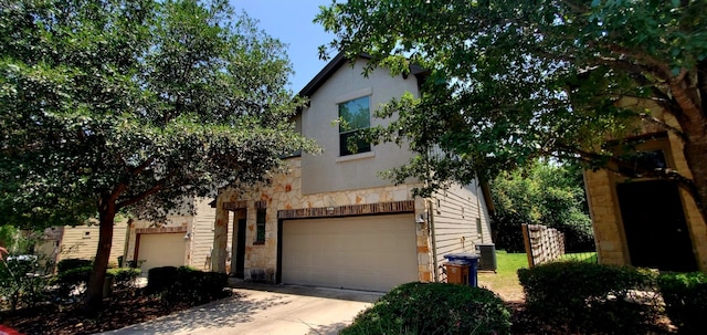 2101 Rivers Edge Way Unit 17, Austin, TX 78741 - view of front of property featuring stone siding, driveway, a garage, and stucco siding