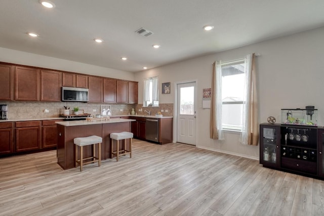 2300 Cliffbrake Way, Georgetown, TX 78626 - kitchen featuring appliances with stainless steel finishes, light countertops, a kitchen breakfast bar, a center island, and light wood-style flooring
