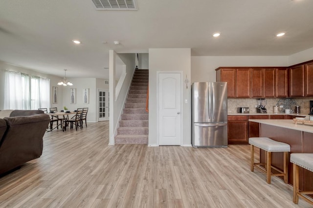 2300 Cliffbrake Way, Georgetown, TX 78626 - kitchen with freestanding refrigerator, open floor plan, light countertops, decorative backsplash, and light wood-style floors