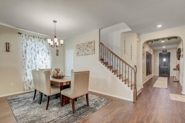 285 Kat Garnet Dr, Kyle, TX 78640 - dining room featuring wood finished floors, a chandelier, arched walkways, recessed lighting, and stairway