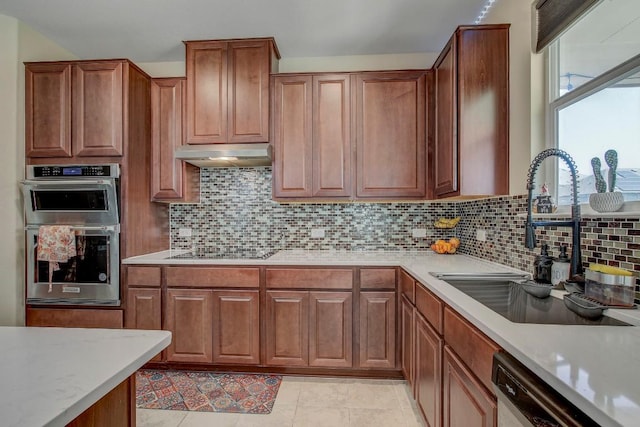 285 Kat Garnet Dr, Kyle, TX 78640 - kitchen featuring double oven, under cabinet range hood, dishwasher, black electric cooktop, and light countertops