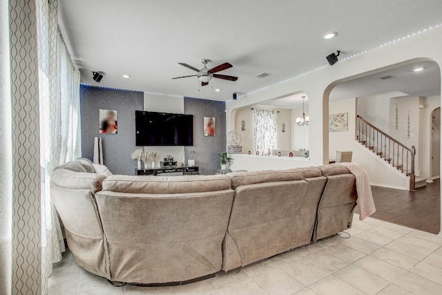 285 Kat Garnet Dr, Kyle, TX 78640 - living area with arched walkways, a ceiling fan, stairway, recessed lighting, and light tile patterned floors