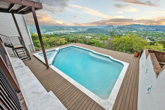 pool at dusk with a fenced in pool