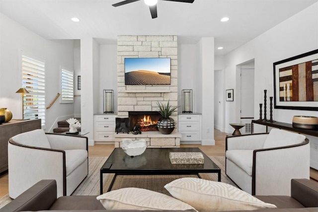 744 Buffalo Trl, Liberty Hill, TX 78642 - living room featuring light wood finished floors, ceiling fan, a stone fireplace, stairway, and recessed lighting