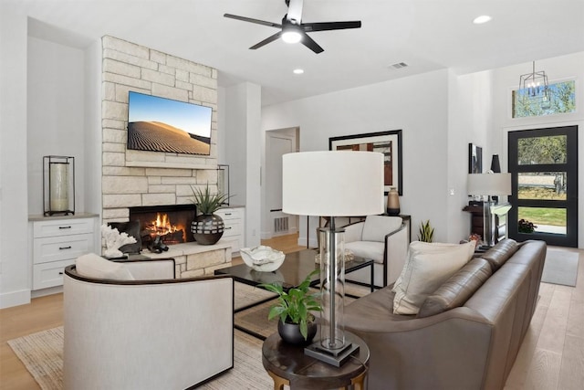 744 Buffalo Trl, Liberty Hill, TX 78642 - living room with light wood finished floors, a stone fireplace, a ceiling fan, and recessed lighting