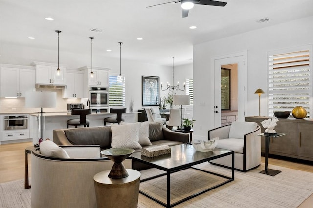 744 Buffalo Trl, Liberty Hill, TX 78642 - living room featuring recessed lighting, a ceiling fan, light wood-style floors, and a chandelier