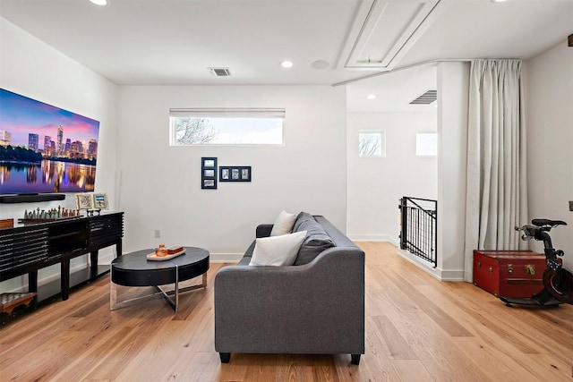 living room featuring attic access, light wood finished floors, visible vents, and recessed lighting