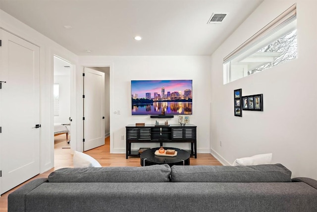 living room with recessed lighting, light wood-type flooring, visible vents, and baseboards