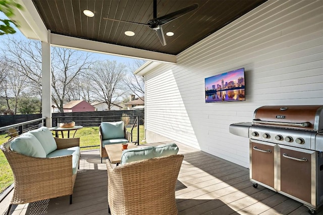 deck with area for grilling, fence, ceiling fan, and an outdoor hangout area