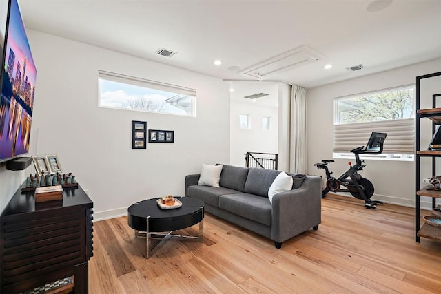 living area featuring attic access, light wood-type flooring, visible vents, and recessed lighting
