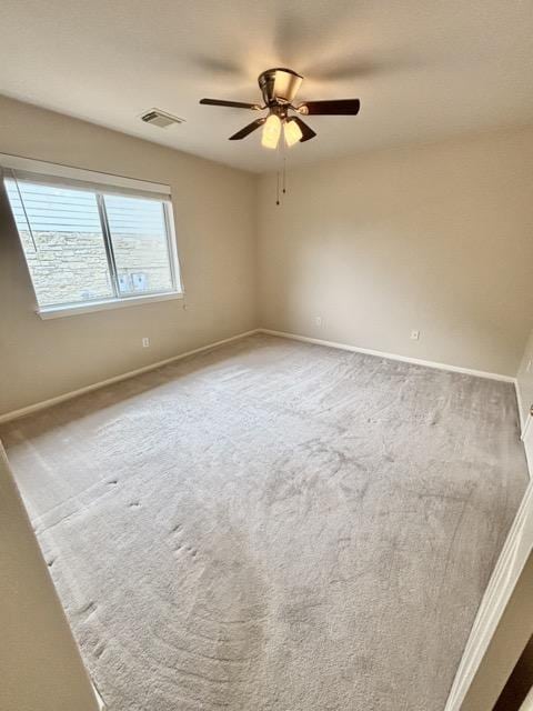 unfurnished room with baseboards, visible vents, ceiling fan, and carpet flooring