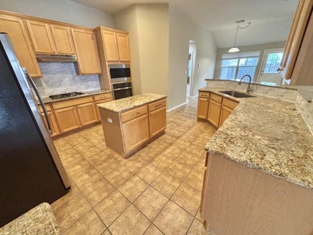kitchen with light brown cabinets, a sink, stainless steel appliances, and under cabinet range hood