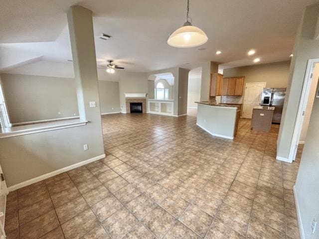 kitchen featuring open floor plan, decorative light fixtures, stainless steel fridge with ice dispenser, baseboards, and a ceiling fan