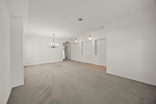 2832 Mission Tejas Dr, Pflugerville, TX 78660 - unfurnished living room featuring a chandelier, carpet, arched walkways, and baseboards