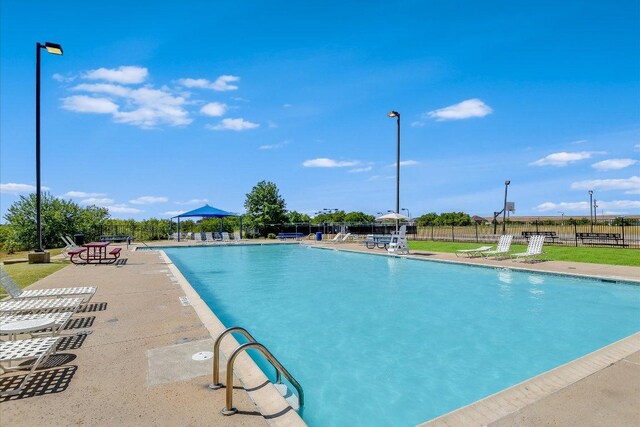 community pool featuring a patio area and fence