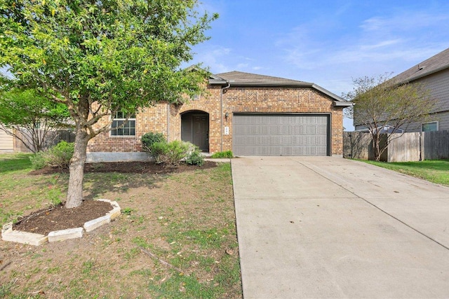 view of front of house with brick siding, driveway, fence, and an attached garage