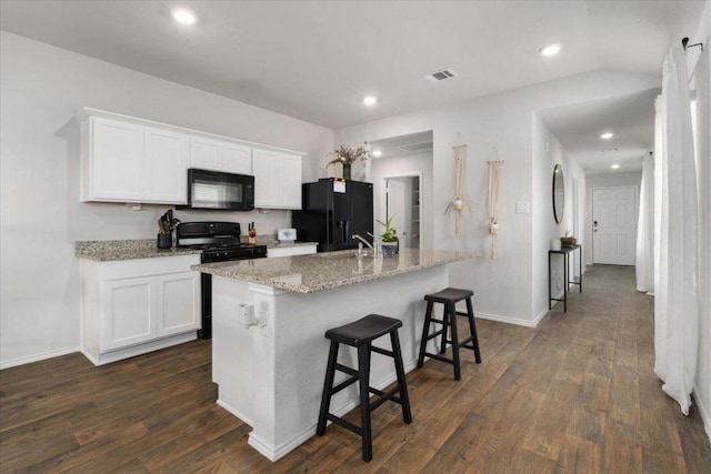249 Calgary Ln, San Marcos, TX 78666 - kitchen featuring black appliances, dark wood-type flooring, a center island with sink, white cabinetry, and light stone counters
