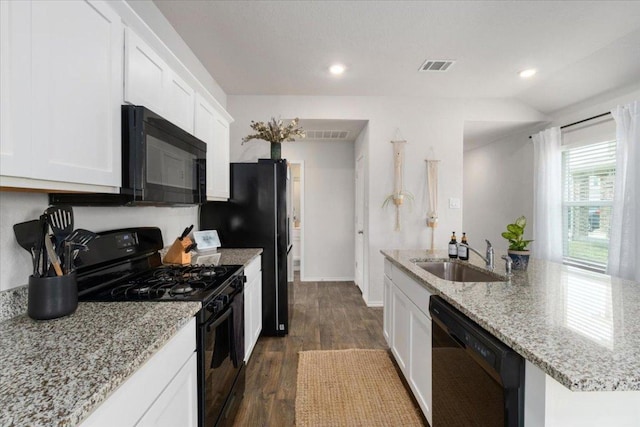 249 Calgary Ln, San Marcos, TX 78666 - kitchen with black appliances, dark wood-style flooring, white cabinets, light stone counters, and recessed lighting