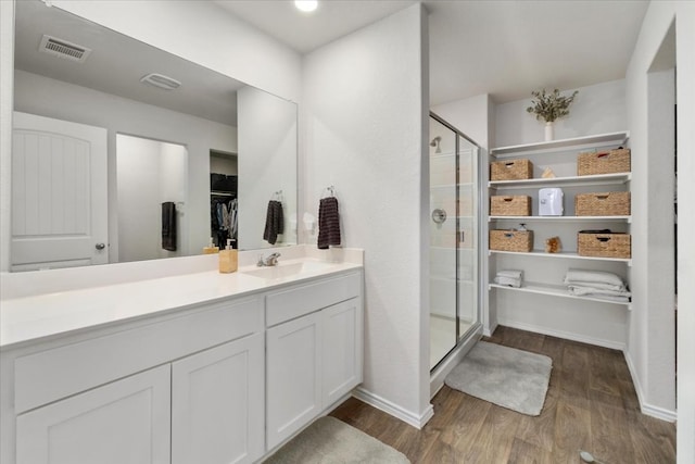 249 Calgary Ln, San Marcos, TX 78666 - full bath featuring wood finished floors, a walk in closet, a shower stall, vanity, and baseboards