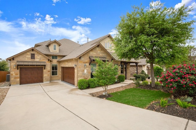 6009 Empresa Dr, Austin, TX 78738 - view of front facade with stone siding, concrete driveway, a shingled roof, and an attached garage