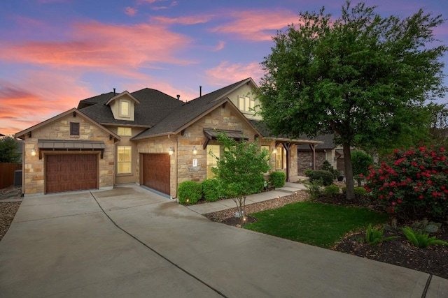 6009 Empresa Dr, Austin, TX 78738 - view of front of home with stone siding, an attached garage, concrete driveway, and roof with shingles