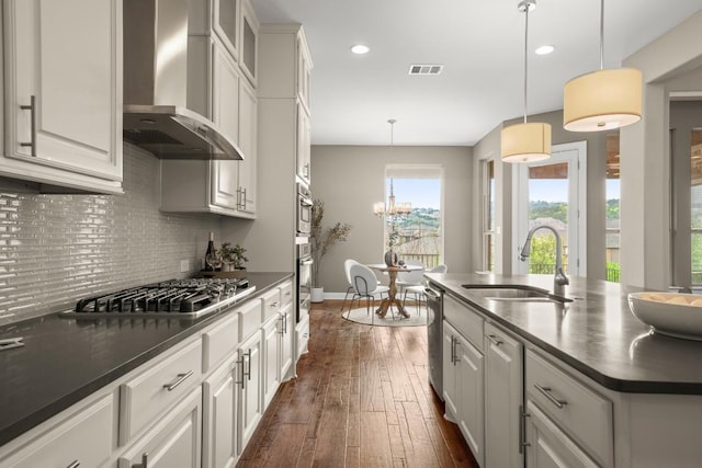 6009 Empresa Dr, Austin, TX 78738 - kitchen featuring wall chimney exhaust hood, dark countertops, a sink, stainless steel appliances, and dark wood-style floors