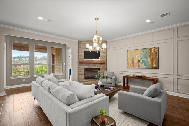 6009 Empresa Dr, Austin, TX 78738 - living room featuring crown molding, a decorative wall, a chandelier, wood-type flooring, and a fireplace