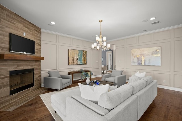 6009 Empresa Dr, Austin, TX 78738 - living area with a decorative wall, ornamental molding, a chandelier, a tile fireplace, and dark wood-type flooring