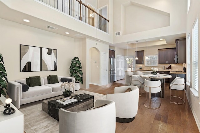 7709 Menchaca Rd Unit 35, Austin, TX 78745 - living area featuring wood finished floors, arched walkways, a high ceiling, and recessed lighting