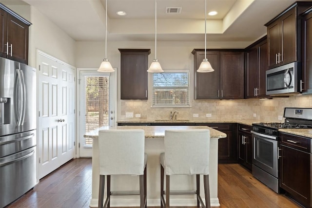 7709 Menchaca Rd Unit 35, Austin, TX 78745 - kitchen featuring appliances with stainless steel finishes, a raised ceiling, plenty of natural light, dark brown cabinets, and recessed lighting