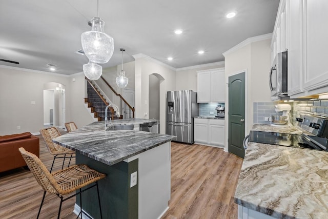 1806 Ashburn Dr, Temple, TX 76502 - kitchen with arched walkways, stainless steel appliances, a breakfast bar area, recessed lighting, and backsplash