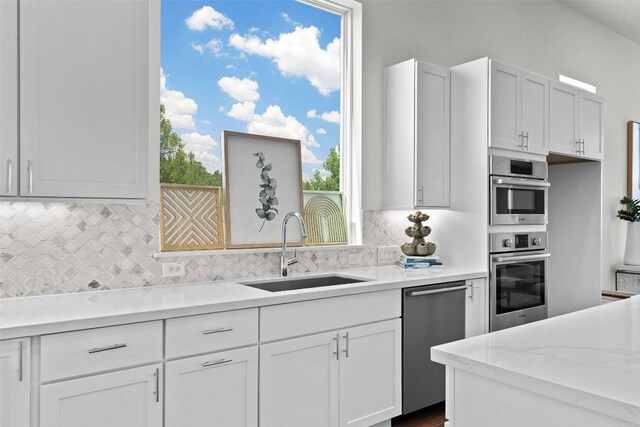 6020 Sendero Hills Pkwy, Austin, TX 78724 - kitchen featuring appliances with stainless steel finishes, backsplash, and white cabinetry