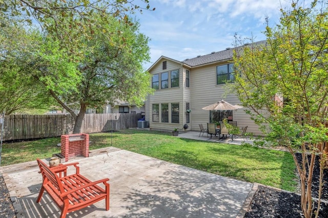 rear view of property featuring fence, a yard, central AC, and a patio
