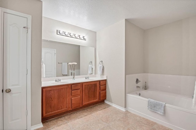 bathroom with double vanity, a garden tub, baseboards, and a sink