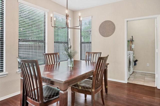 dining room with baseboards, a notable chandelier, wood finished floors, and independent washer and dryer