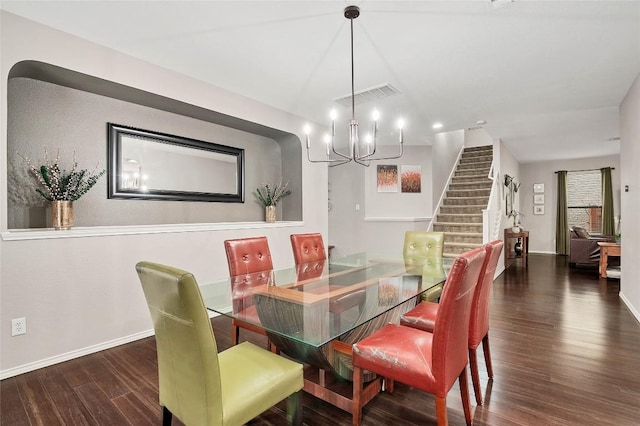 dining space with baseboards, visible vents, a chandelier, wood finished floors, and stairway