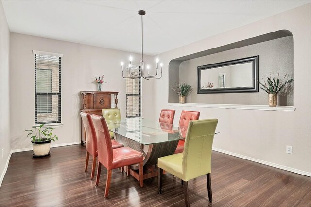 dining room with wood finished floors, baseboards, and a notable chandelier